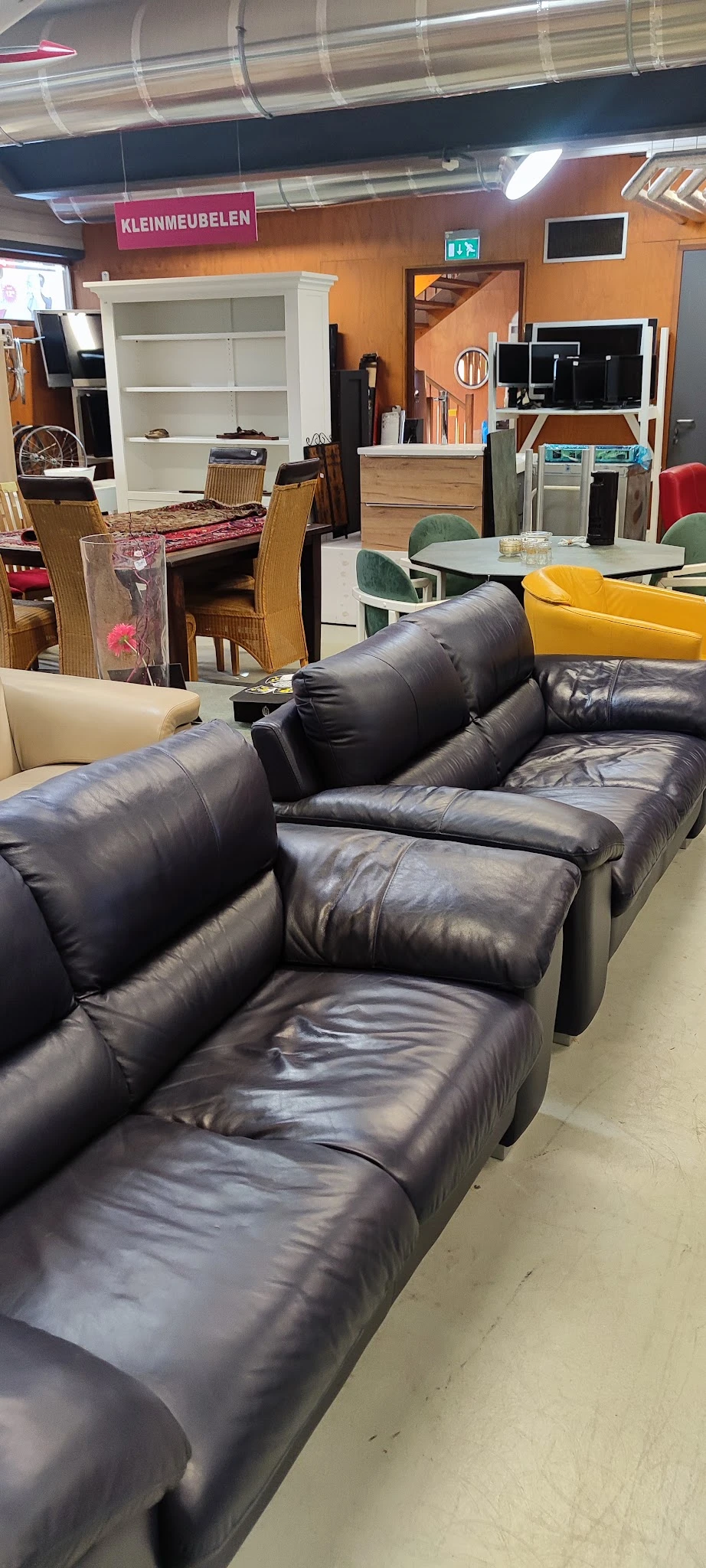 Zwarte leren fauteuil met hoofdsteunen in een kringloopwinkel