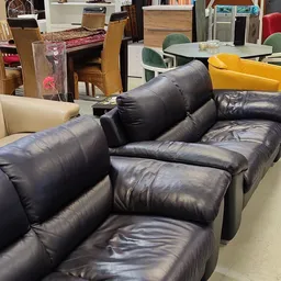 Zwarte leren fauteuil met hoofdsteunen in een kringloopwinkel