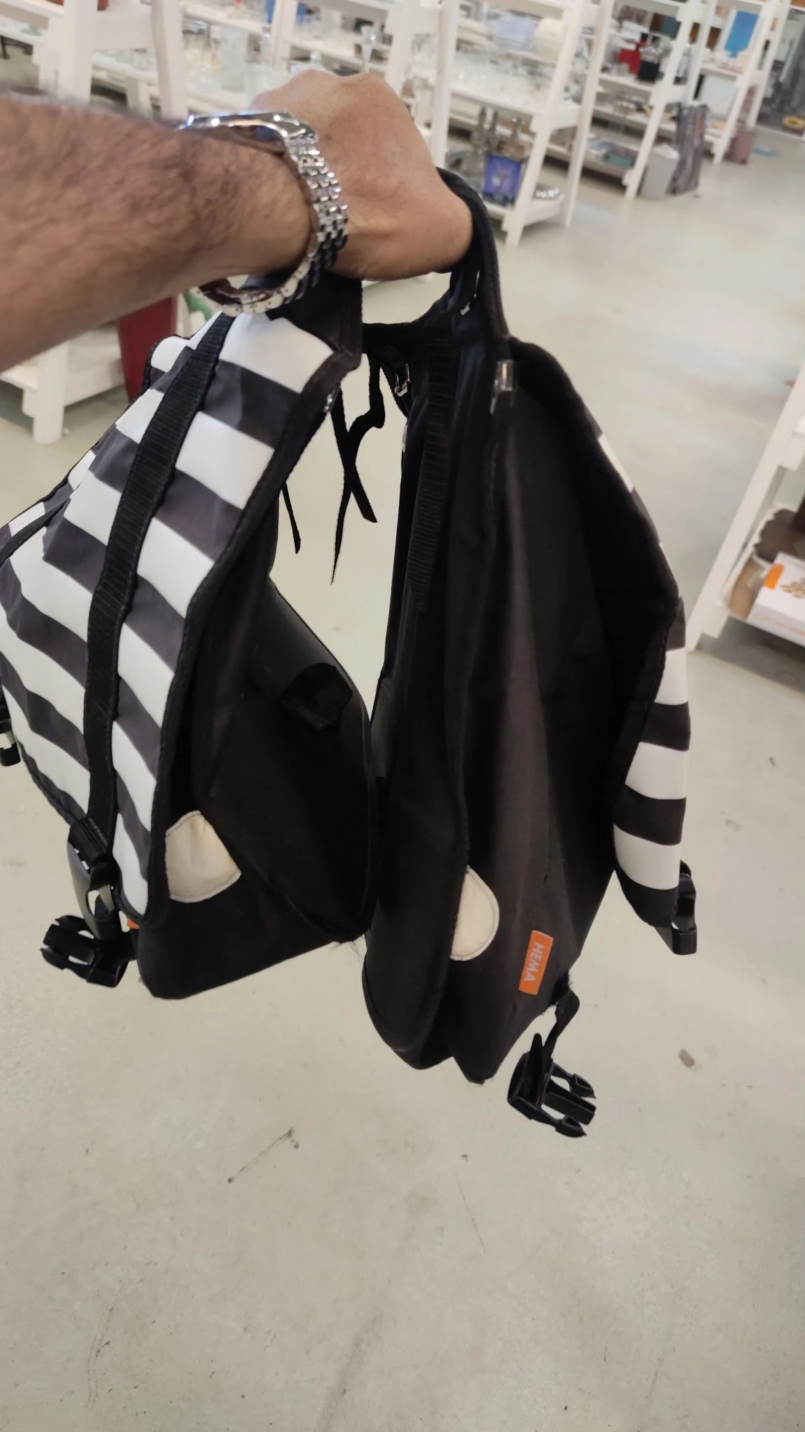 Zwarte rugzak met wit geruit patroon en gekleurde labels, detail van de voorzijde
