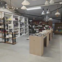 Winkelinterieur met stellingen, kastjes en toonbanken vol spullen, hanglampen aan het plafond