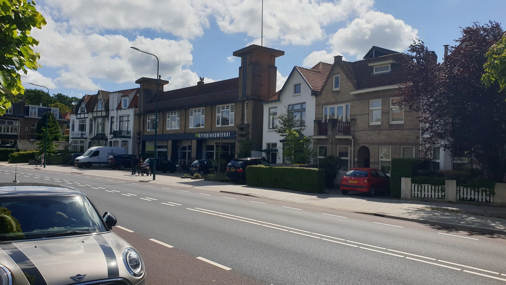Straatgevel van kringloopwinkel met donkerblauwe pui, aangrenzen aan andere historische panden