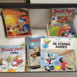 Verzameling tweedehands Donald Duck strips en boeken in een winkelkast