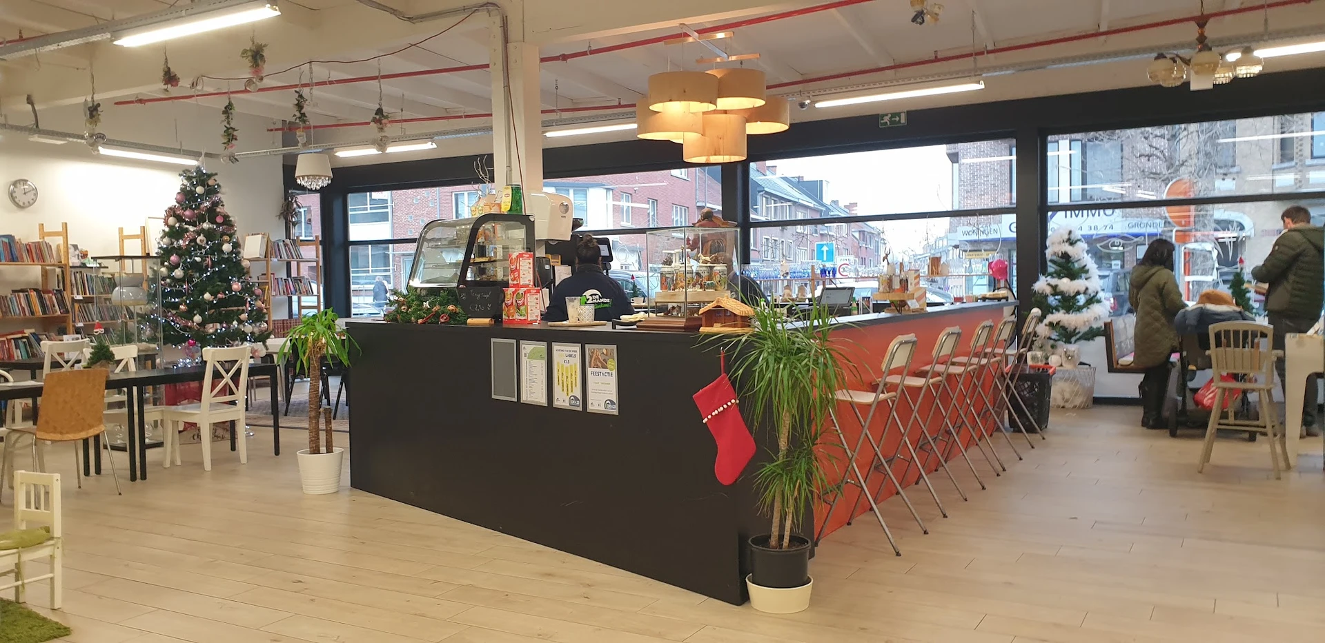Koffiebar of lunchcounter met zwarte balie, rode stoelen en kerstdecoratie in kringloopwinkel