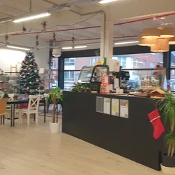 Winkelinterieur met kerstdecoratie, toonbank, zithoeken en diverse artikelen op stellingen