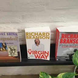 Drie boeken op een zwarte plank: 'Intengendeel' van André Brink, 'De Virgin Way' van Richard Branson en een boek van Richard 