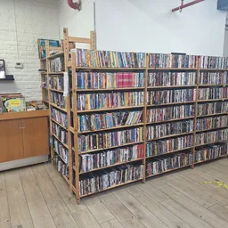 Grote houten boekenkast met honderden dvd's en blu-rays netjes gerangschikt in rijen
