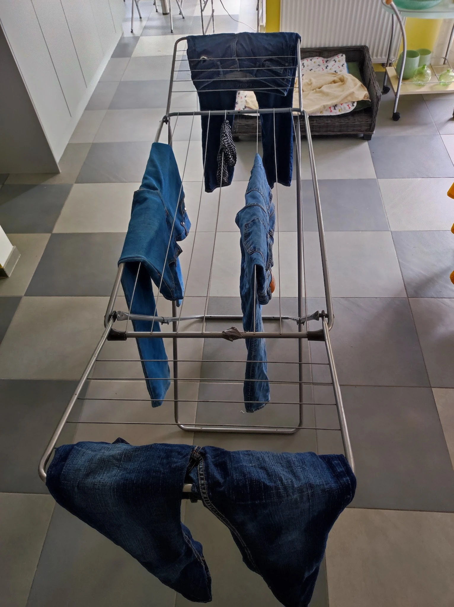 Droogrek met blauwe jeans en ander wasgoed aan hangers