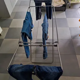 Droogrek met blauwe jeans en ander wasgoed aan hangers