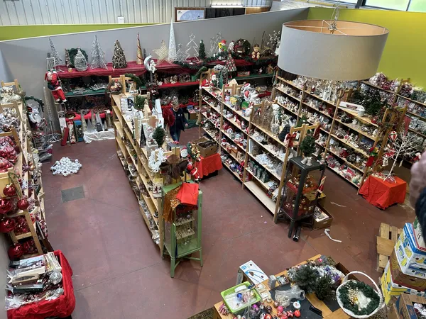 Overzicht van de winkelvloer met stellingen vol kerstdecoratie, slingers en seizoenartikelen