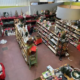 Overzicht van de winkelvloer met stellingen vol kerstdecoratie, slingers en seizoenartikelen
