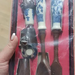 Close-up van een donkere keukengereedschapset met houten handvatten in verpakking