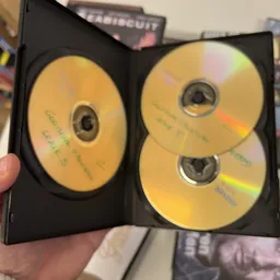 Twee geopende dvd-boxen met beschreven gele schijven in zwarte houders
