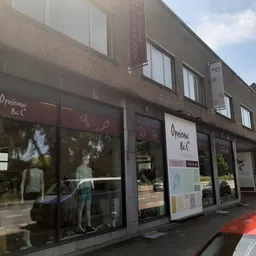 Gevel van kringloopwinkel met etalageruiten, winkelnaam en uitstallingen zichtbaar