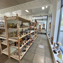 Houten stellingen met verzameling beeldjes, poppen en decoratieve items in winkelruimte