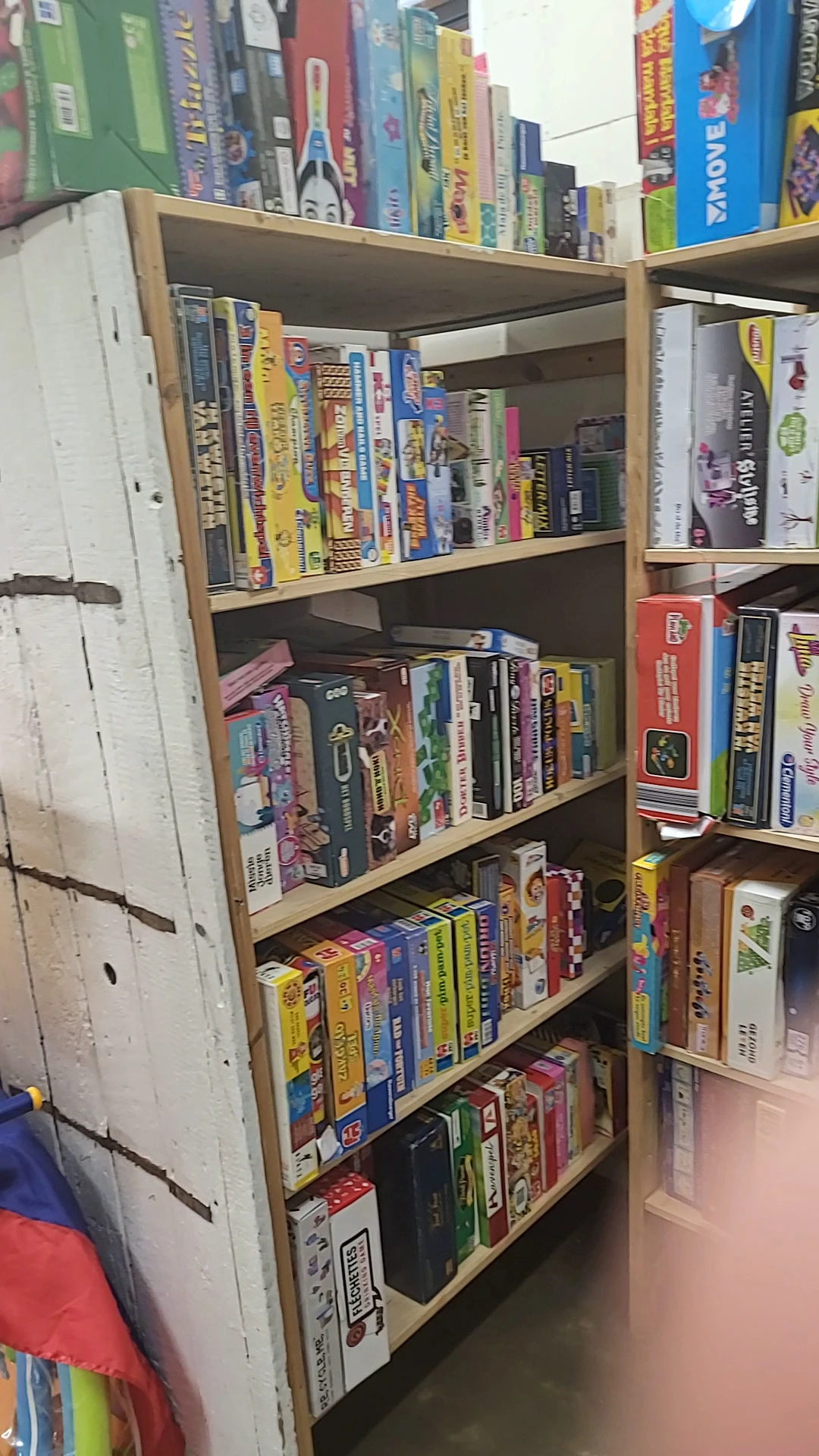 Houten stellingkast met bordspellen, dvd's en boeken netjes uitgestald op drie niveaus