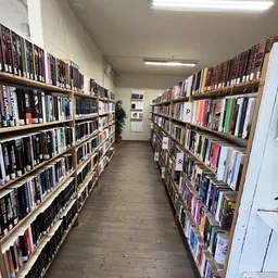 Gang tussen twee stellingen vol met dvd's en blu-rays in een kringloopwinkel