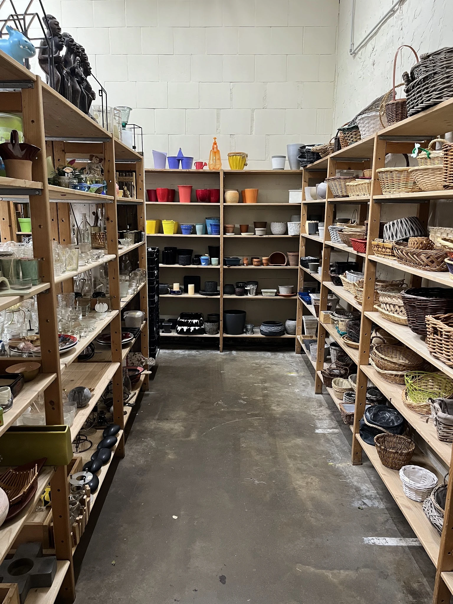 Winkelinterieur met houten stellingen vol huishoudartikelen, manden en serviesgoed