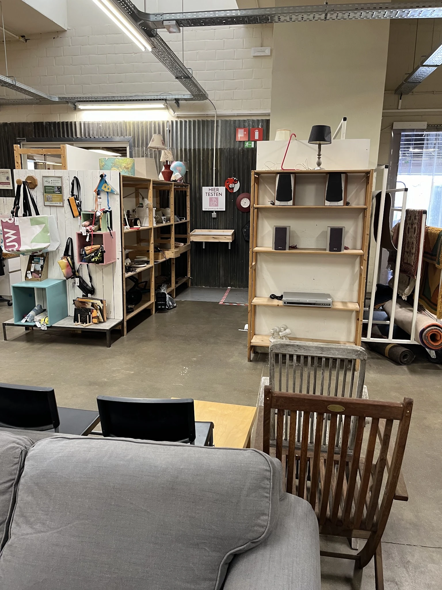 Overzicht van de winkelruimte met houten stellingen, uitgestalde meubels en decoratieartikelen