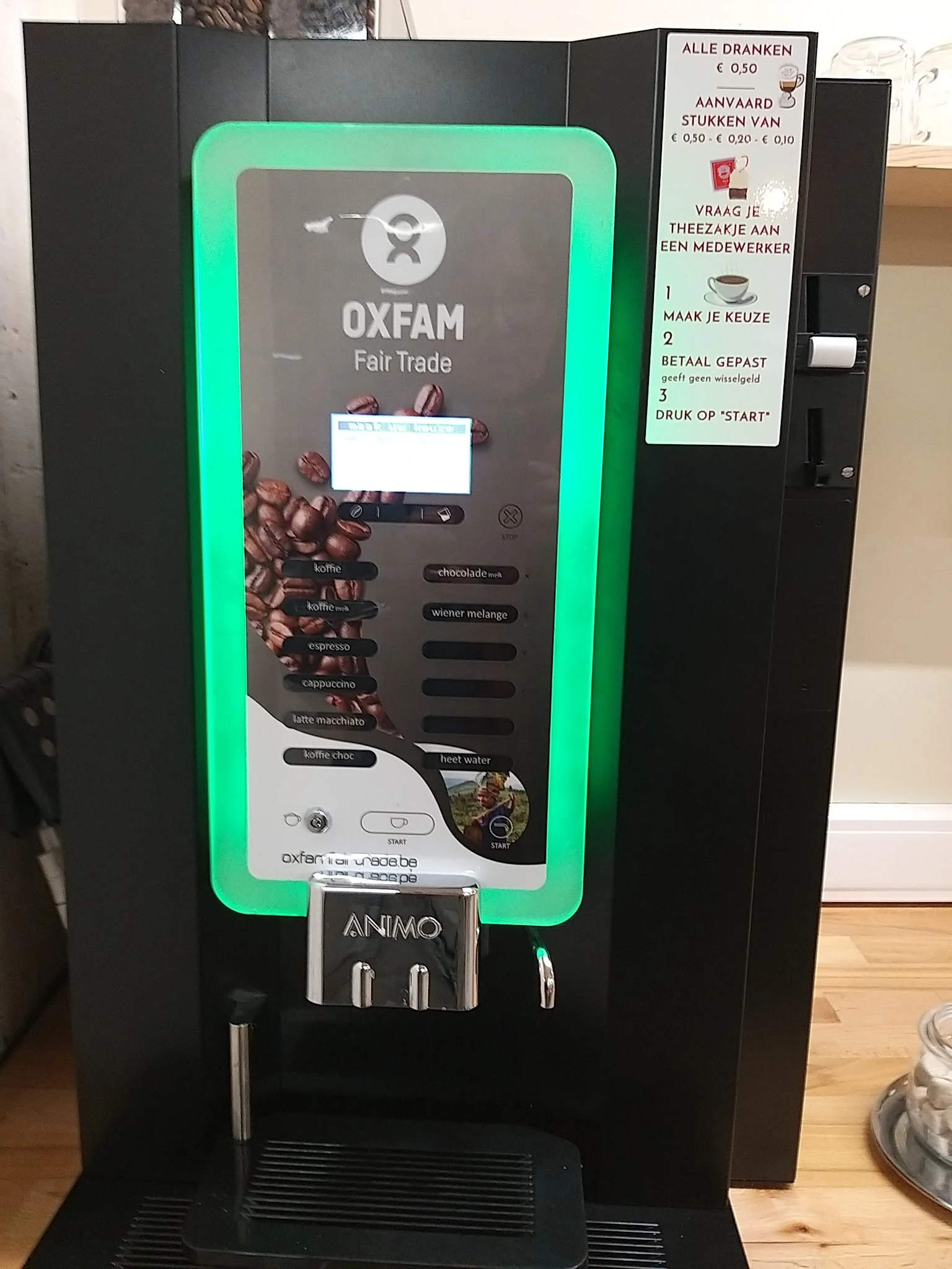 Close-up van een groene koffieautomaat voor Oxfam Fair Trade koffie met touchscreen en instructies