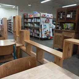 Winkelvloer met houten meubels, boekenrekken en kastjes vol tweedehands spullen