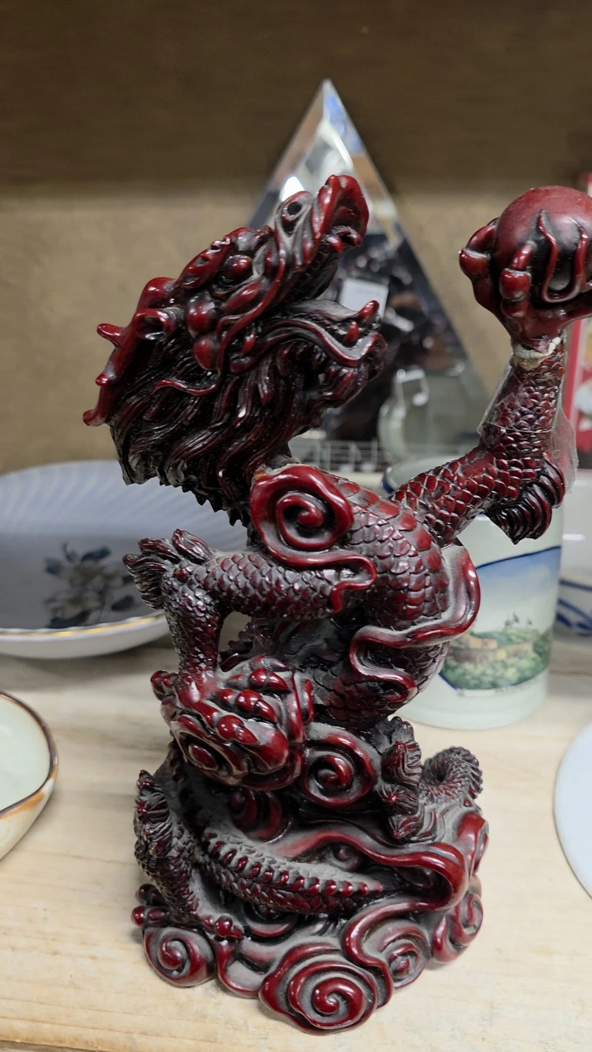 Close-up van een rood-zwart decoratief drakenolifantbeeldje uit keramiek of porselein
