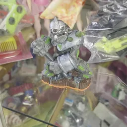 Close-up van een grijs speelgoedactiefiguur met groen accenten op houten voet