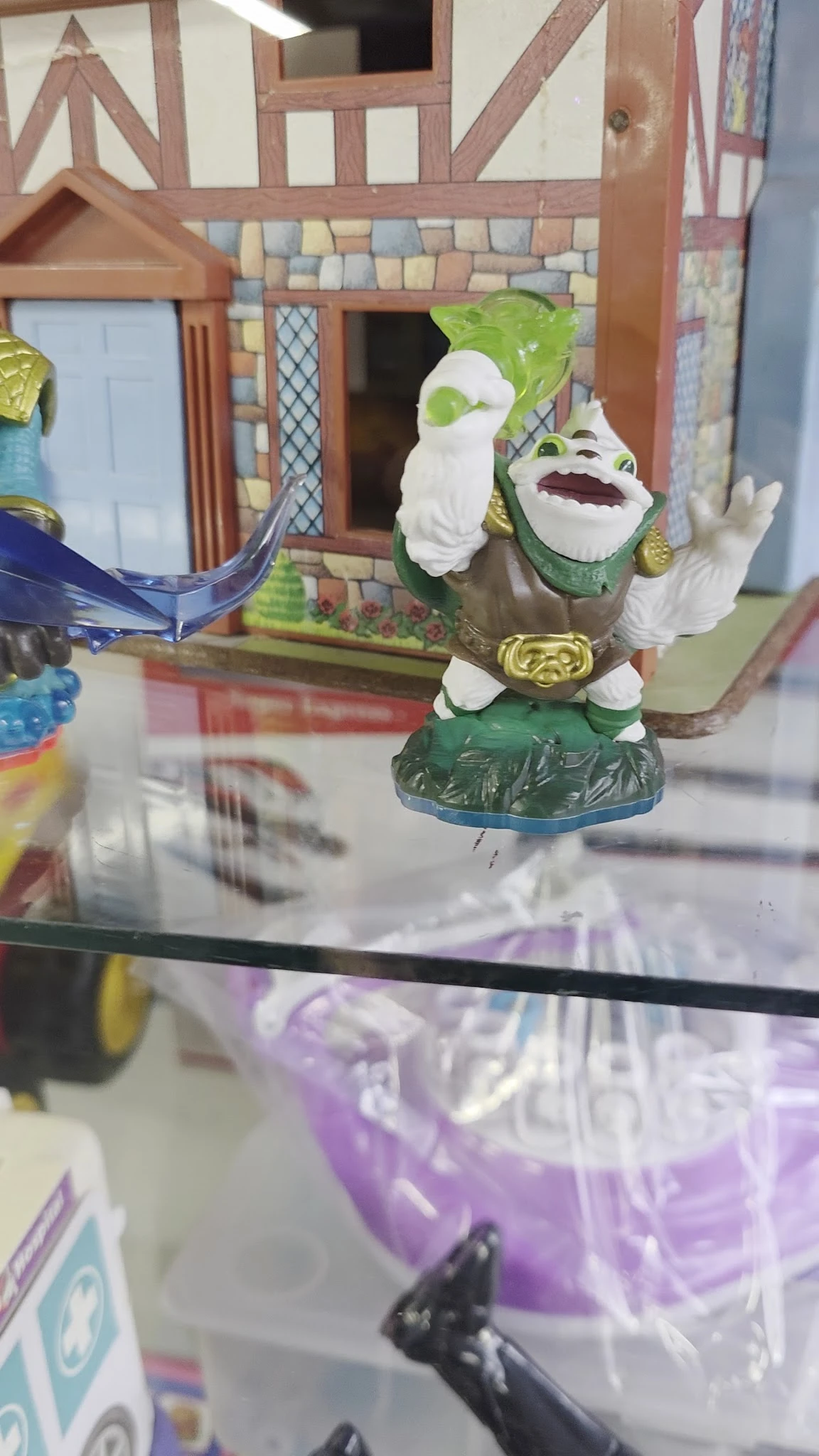 Close-up van een groene speelfiguur met witte details en gouden accessoires