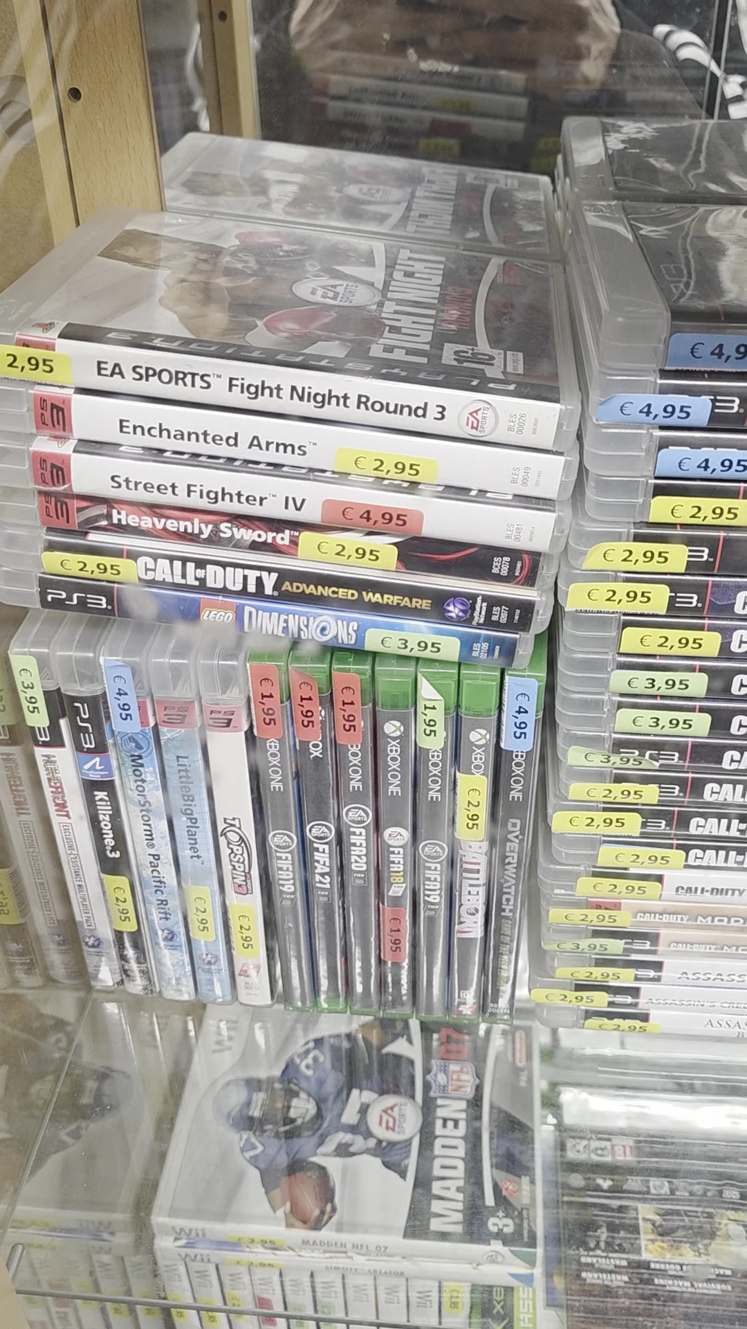 Rekken met tweedehands PlayStation 3-games, waaronder Call of Duty, Street Fighter en Lego Dimensions, met prijskaartjes
