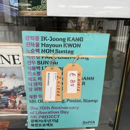 Turquoise bord met Koreaanse namen en twee oranje nummerlabels eraan bevestigd
