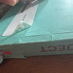 Close-up van een turquoise surfboard of boogie board met rode logo, met een prijskaartje erop