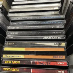 Stapel cd's en dvd's met verschillende titels in plastic hoezen