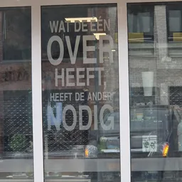 Winkelruit met wit raamlettering 'WAI DE EEN OVER HEEFT, HEEFT DE ANDER NODIG'