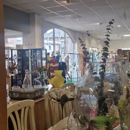 Winkelinterieur met displaykasten, kunstobjecten en decoraties, grote raam op straat