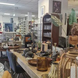 Winkelbinnenruimte met toonbanken, stellingen, diverse gebruiksartikelen en decoratie-items