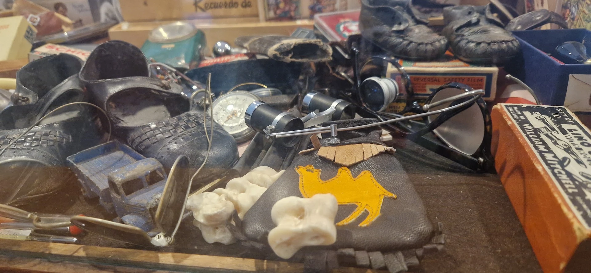 Verzameling tweedehandsartikelen op tafel: schoenen, koptelefoons, speelgoed en overige huishoudelijke spullen