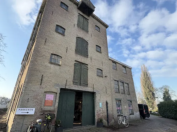 Bakstenen winkelgebouw met groene deuren en ramen, fietsen ervoor geparkeerd