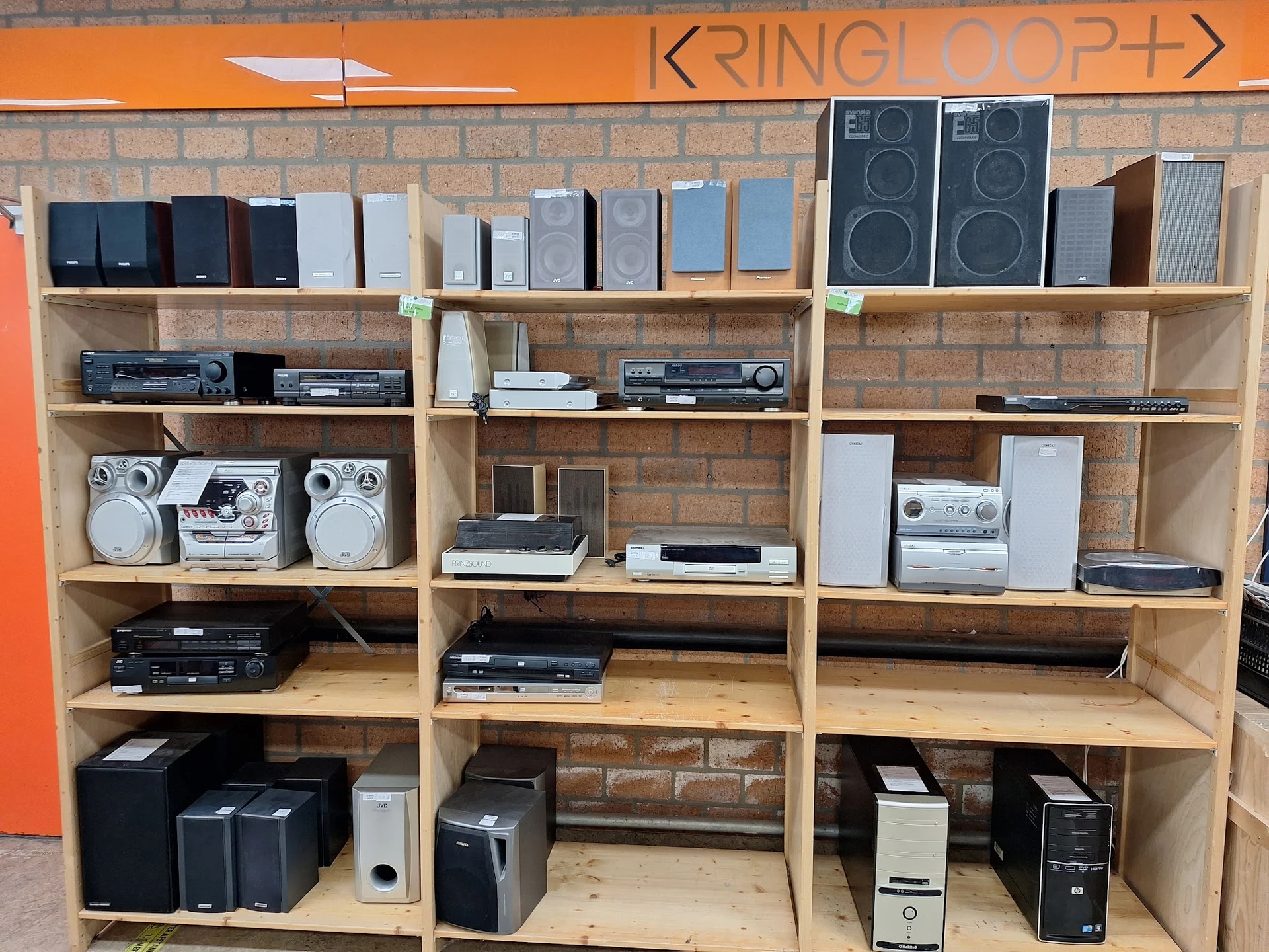 Houten stellingen met elektronische apparatuur: speakers, versterkers, cd-spelers en andere audio-apparaten.