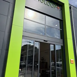 Winkelgevel met fluorescerend groene zijkanten en grote glazen ramen en deur