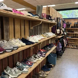 Houten stellingen met uitgestalde schoenen en kleding in verschillende kleuren