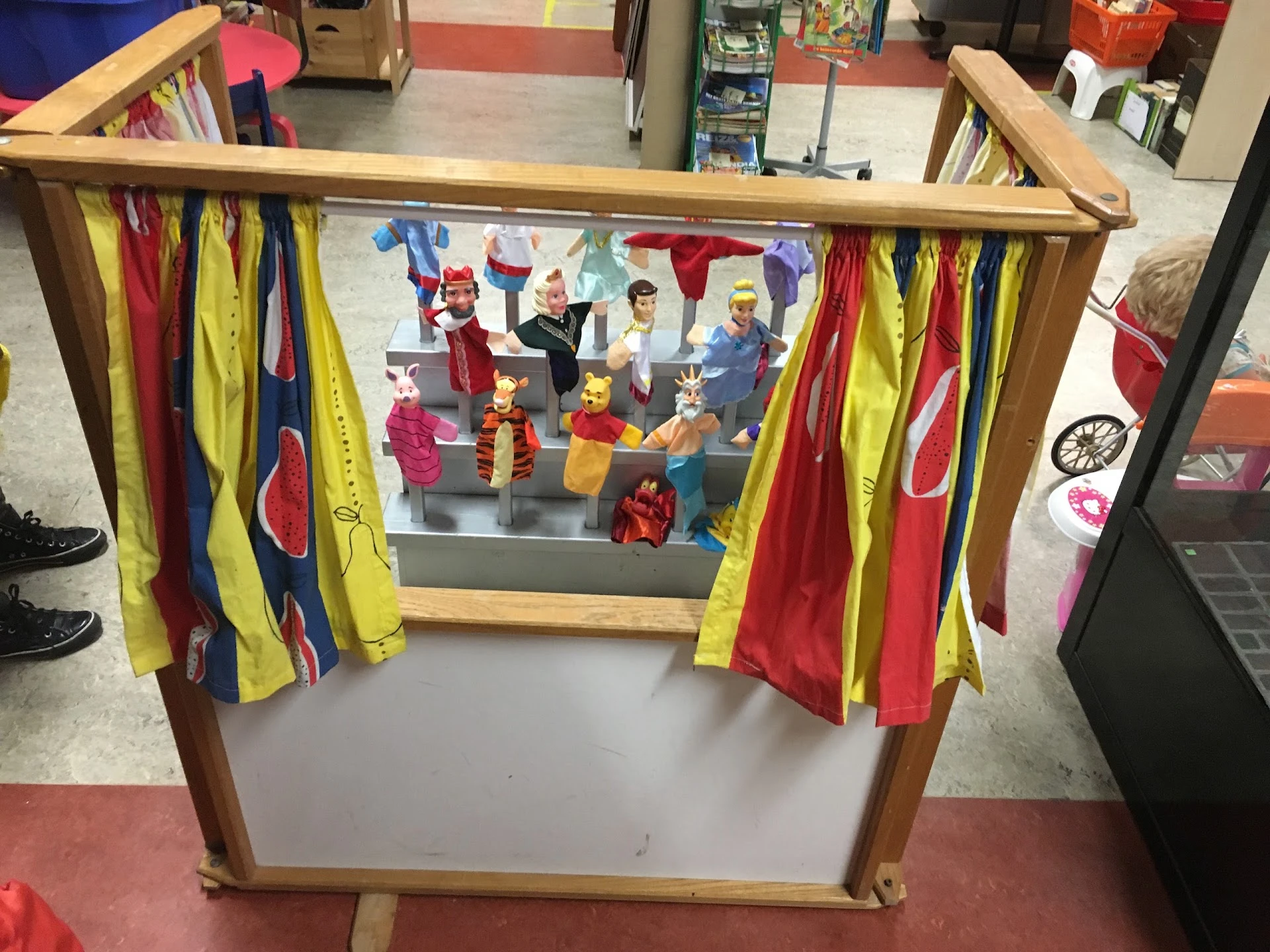Houten poppentheater met gekleurde gordijnen en afbeelding van figurines op het doek