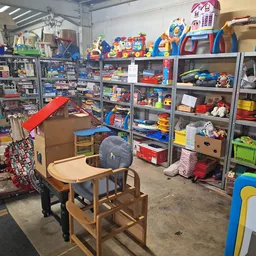 Winkelvloer met metalen stellingen vol speelgoed, kinderstoelen en diverse artikelen