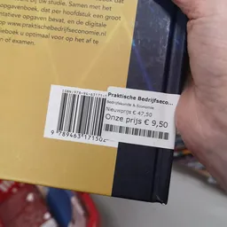 Prijssticker op een boek met titel 'Praktische Bedrijfseconomie', met oorspronkelijke prijs €47,50 en verkoopprijs €9,50