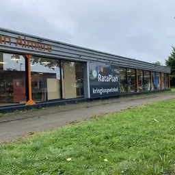 Voorgevel van kringloopwinkel met donkerblauwe pui, grote ramen en winkelnaam RataPlan zichtbaar