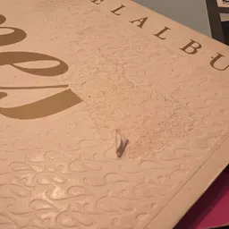 Closeup van een wit boek of notitieboek met decoratief patroon en gedeeltelijk zichtbare tekst