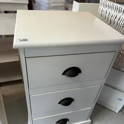 Witte ladekast met twee zwarte handgrepen, getoond in een kringloopwinkel