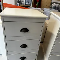 Witte ladekast met twee laden en zwarte greepkuilen, gezien van voren