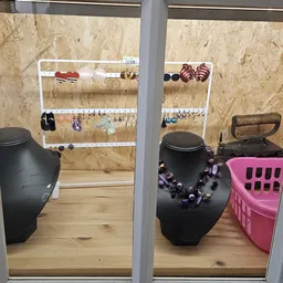 Uitgestalde sieraden en accessoires op mannequins en organizers in de winkel