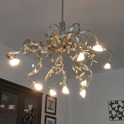 Goudkleurige hanglamp met meerdere armen en glazen kappen aan het plafond