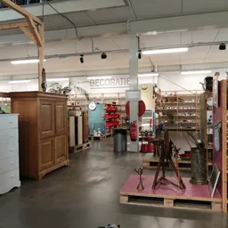 Overzicht van de winkelvloer met meubels, kasten, decoratie-items en stellingen vol huishoudspullen