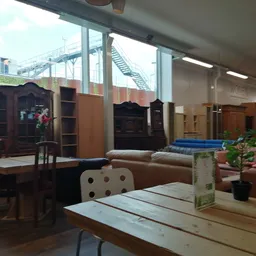 Winkelvloer met verschillende meubelstukken, kasten en een houten tafel op de voorgrond